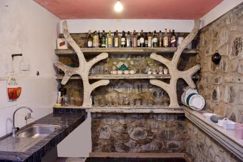 a bar with antlers on the wall and a sink at Roshan Guest House in Nuwara Eliya