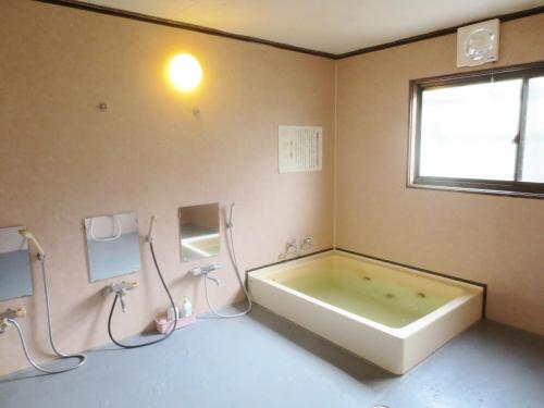 湯沢町にあるペンション　ノアの窓付きのバスルーム(大型バスタブ付)