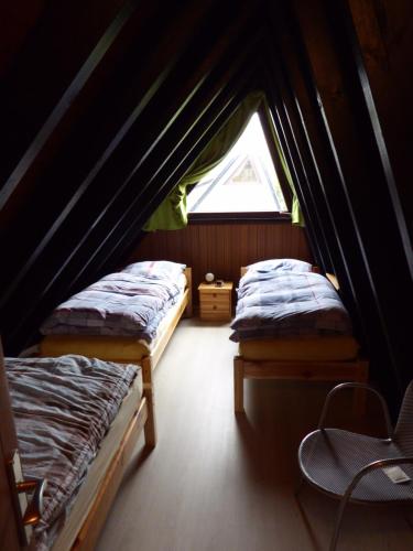 two beds in a small room with a window at Eifelwaldhäuschen in Blankenheim