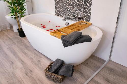 a white bath tub in a bathroom with a plant at LA POSADA DE MYA in Villarejo de Salvanés