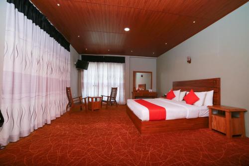Habitación de hotel con cama, mesa y sillas en OYO 278 Hotel Rivelka, en Kundasale
