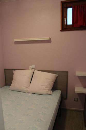 - un lit avec un oreiller dans l'établissement Apartement sur les hauteurs de Gerardmer avec une SUPERBE VUE, à Gérardmer