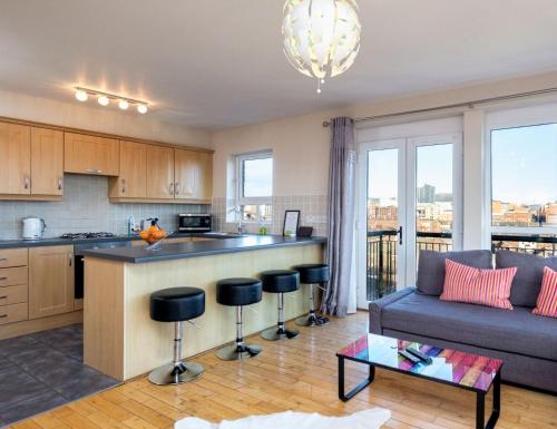 une cuisine et un salon avec un canapé et une table dans l'établissement Ultra Urban Belfast Apartments, à Belfast