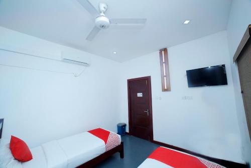 a bedroom with a bed and a tv on the wall at Station Garden Hotel And Resturant in Jaffna