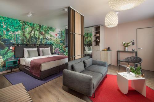 a bedroom with a bed and a couch and a chair at Cortile Hotel - Adults Only in Budapest