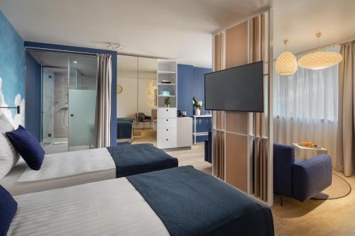 a bedroom with a bed and a tv and a couch at Cortile Hotel - Adults Only in Budapest