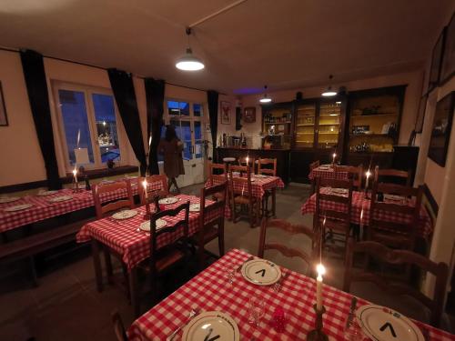 un restaurant avec des tables et des chaises rouges et blanches et des bougies dans l'établissement Three rooms above a bar Résistance meuseum, à Saint-Sébastien