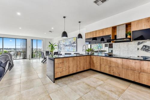 an open kitchen with a large island in the middle at CONROE EXECUTIVE TOWNHOUSE - MODERN & STYLISH in Mount Gambier
