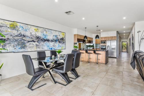 - une cuisine et une salle à manger avec une table et des chaises dans l'établissement CONROE EXECUTIVE TOWNHOUSE - MODERN & STYLISH, à Mount Gambier