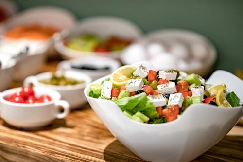 a salad in a white bowl on a wooden table at Vera Hills Boutique Hotel in Tbilisi City