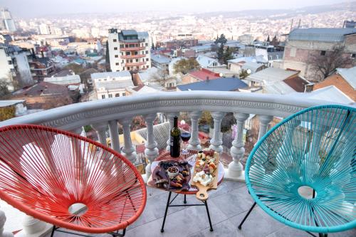 two chairs and a table on a balcony with a view at Vera Hills Boutique Hotel in Tbilisi City