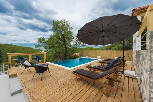 eine Terrasse mit Stühlen und einem Sonnenschirm neben einem Pool in der Unterkunft Villa Dundo Pero in Babino Polje