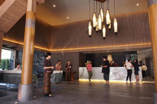 a group of people standing in a lobby at The Teak Hotel in Mae Sot