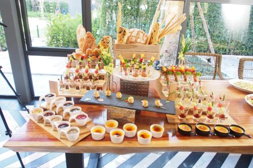 a table with a bunch of different types of food at The Teak Hotel in Mae Sot