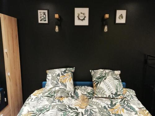- une chambre avec un lit et des photos sur le mur dans l'établissement SLEEP IN COLMAR - Parking - Centre, à Colmar