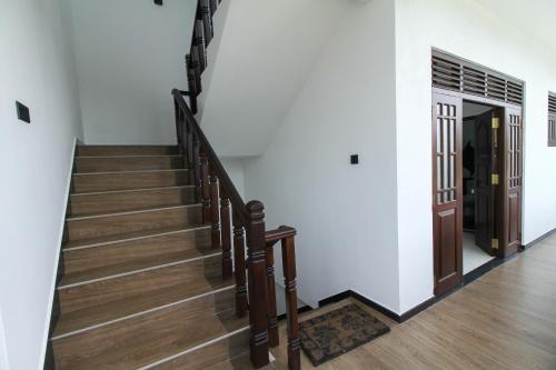 a stairway with wooden stairs and a door at Royal Rich Villa in Ambalangoda