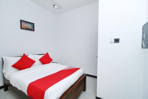 a bedroom with a bed with red and white pillows at Royal Rich Villa in Ambalangoda