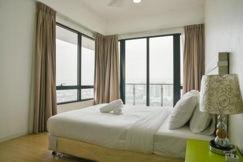 a bedroom with a large white bed with windows at USJ One Premium Suites @Subang @Sunway @USJ in Subang Jaya