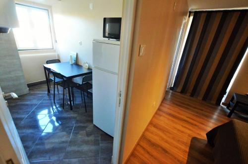a kitchen with a table and a refrigerator at Suites & Apartments - DP Setubal in Setúbal