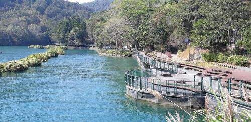 a river with a pier and benches on the side at Ze Hu B&B in Yuchi