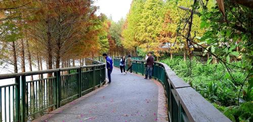 three people walking on a bridge over a river at Ze Hu B&B in Yuchi