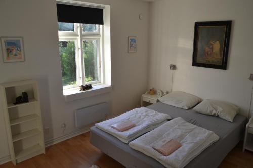 a bedroom with a bed with white sheets and a window at Vilstruplund in Otterup