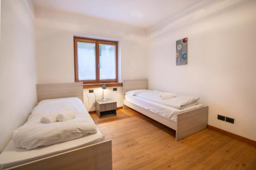 a bedroom with two beds and a window at Dolomites Seasons in Alleghe