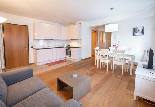 a living room and kitchen with a couch and a table at Dolomites Seasons in Alleghe