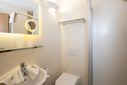 a bathroom with a shower and a toilet and a sink at Angerer Alpine Suiten und Familienappartements Tirol in Reith im Alpbachtal