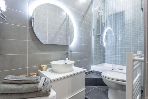 une salle de bain avec un lavabo, des toilettes et un miroir dans l'établissement Lumignons Lyonnais - Presqu'île Confluence, à Lyon