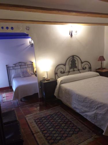 a bedroom with two beds and a lamp on a table at Fonda Del Tozal in Teruel