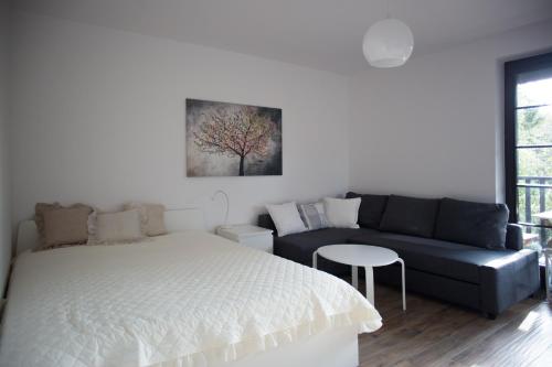 ein Schlafzimmer mit einem Bett und einem Sofa in der Unterkunft Apartament Kameralny in Kazimierz Dolny