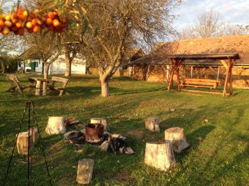a park with a bench and a bunch of logs at Erdősmecskei sváb vendégházak és Jurtaszállás in Erdősmecske