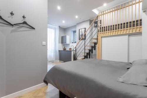 une chambre avec un grand lit et un escalier dans l'établissement Lumignons Lyonnais - Presqu'île Confluence, à Lyon
