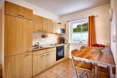 eine Küche mit Holzschränken und einem Holztisch in der Unterkunft Apartmány Happy Klínovec in Loučná pod Klínovcem