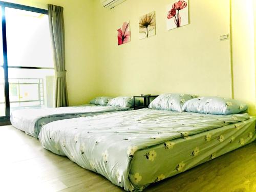 two beds sitting next to each other in a room at Chu House in Donggang
