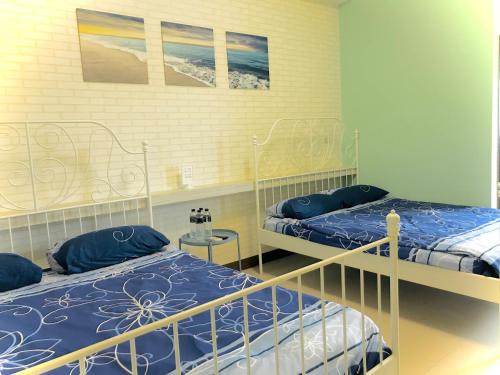 a bedroom with two beds with blue pillows at Chu House in Donggang