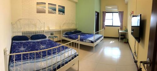 a room with two beds and a tv in it at Chu House in Donggang