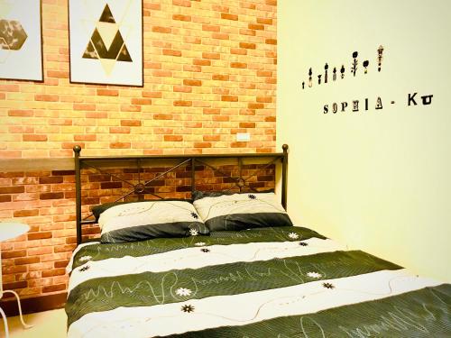 a bed in a room with a brick wall at Chu House in Donggang