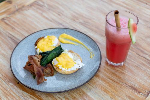 un piatto di prodotti per la colazione e una bevanda su un tavolo di Sunrise Cottage a Nusa Penida