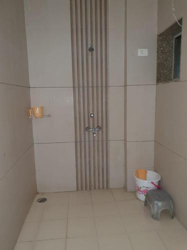 a shower stall in a bathroom with a bucket at HOTEL MANUHAR INN in Bārmer