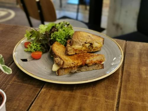 einen Teller mit einem Sandwich und Gemüse auf dem Tisch in der Unterkunft Walk Inn Váci 42 in Budapest