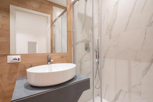 a bathroom with a white sink and a shower at Rooftop San Marco - Tower View in Venice