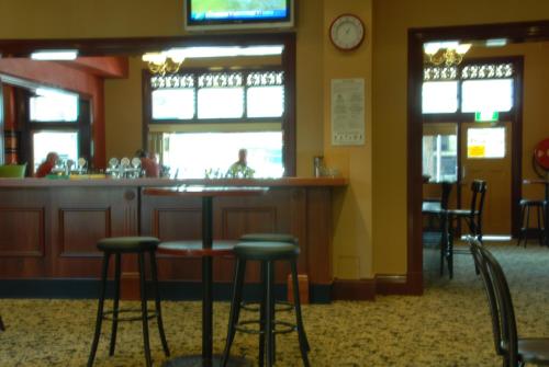 a bar in a restaurant with stools at a counter at Captain Cook Hotel Botany in Sydney