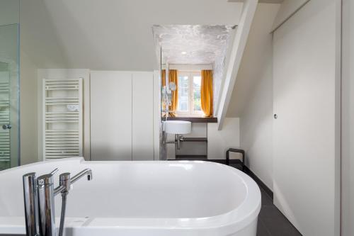 a bathroom with a white tub and a sink at Restaurant Hotel Didier M&eacute;ril in Dinard