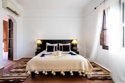 a bedroom with a large bed in a white room at Kasbah Caracalla in Aghmat
