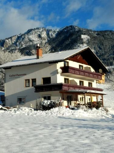 a building in the snow with mountains in the background at Gailtal Panorama in Kötschach
