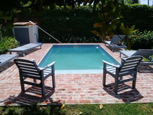 タンディルにあるCasa Chacabuco Tandilのスイミングプール(椅子2脚、ペア1脚付)