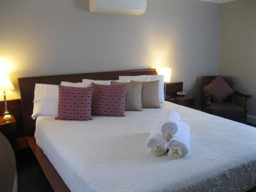 un dormitorio con una cama con dos animales de peluche en Heritage Guesthouse en South West Rocks