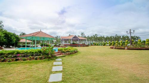 a garden with a swimming pool and a resort at Fiestaa Resort n Events Venue in Devanahalli-Bangalore